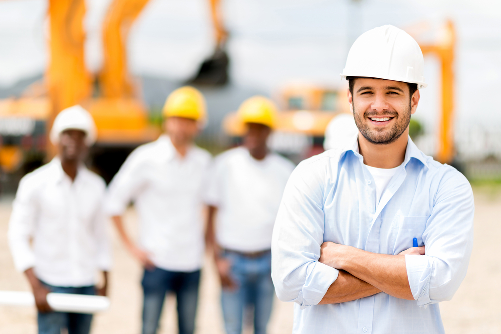 Male architect at a construction site looking happy